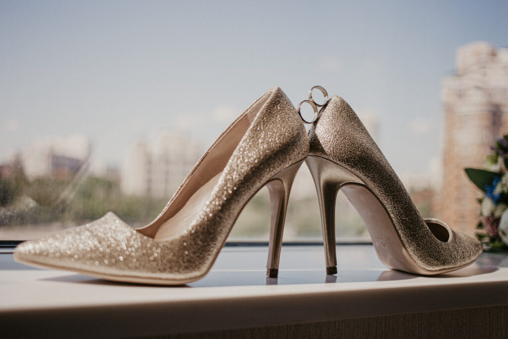 gold-wedding-rings-pair-golden-high-heel-shoes